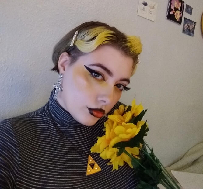 A picture of my face, with yellow hair, holding yellow flowers